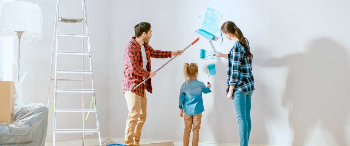 A family of three painting walls